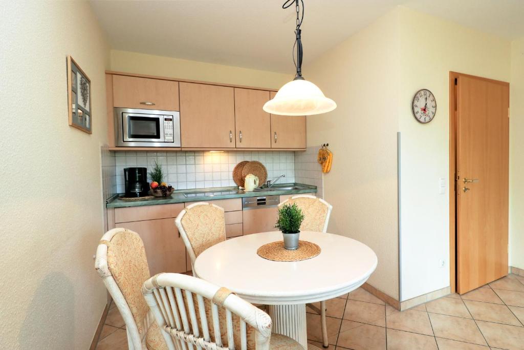 a small kitchen with a white table and chairs at Altes Wasserwerk App 03 in Wustrow