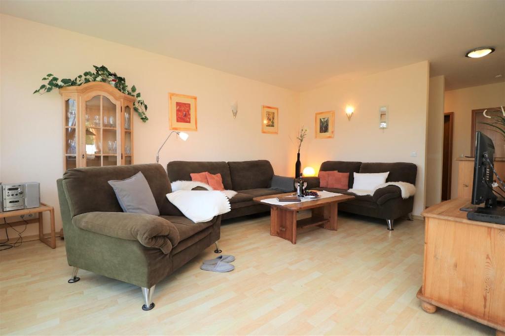 a living room with two couches and a table at Wohnpark Schmiedestraße App 15 in Wustrow
