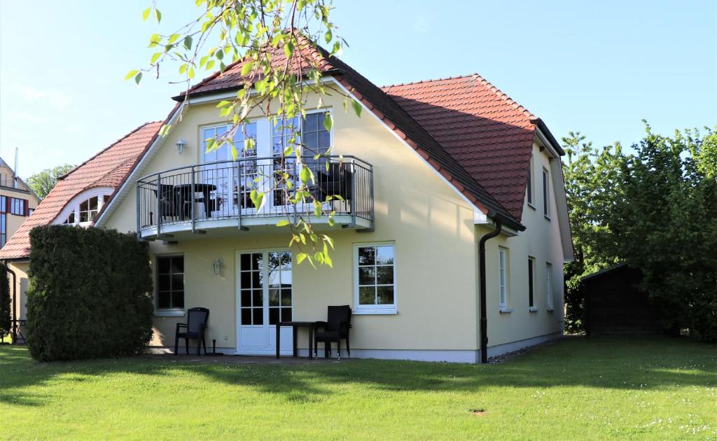 een wit huis met een balkon en een tafel bij Achtern Hafen App 01 in Wustrow