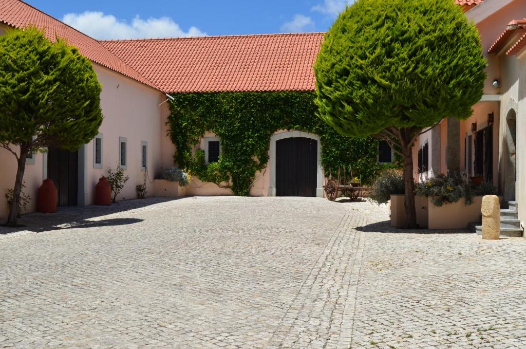 einen Innenhof eines Hauses mit Bäumen und einer Auffahrt in der Unterkunft Quinta do Covanco in Alenquer