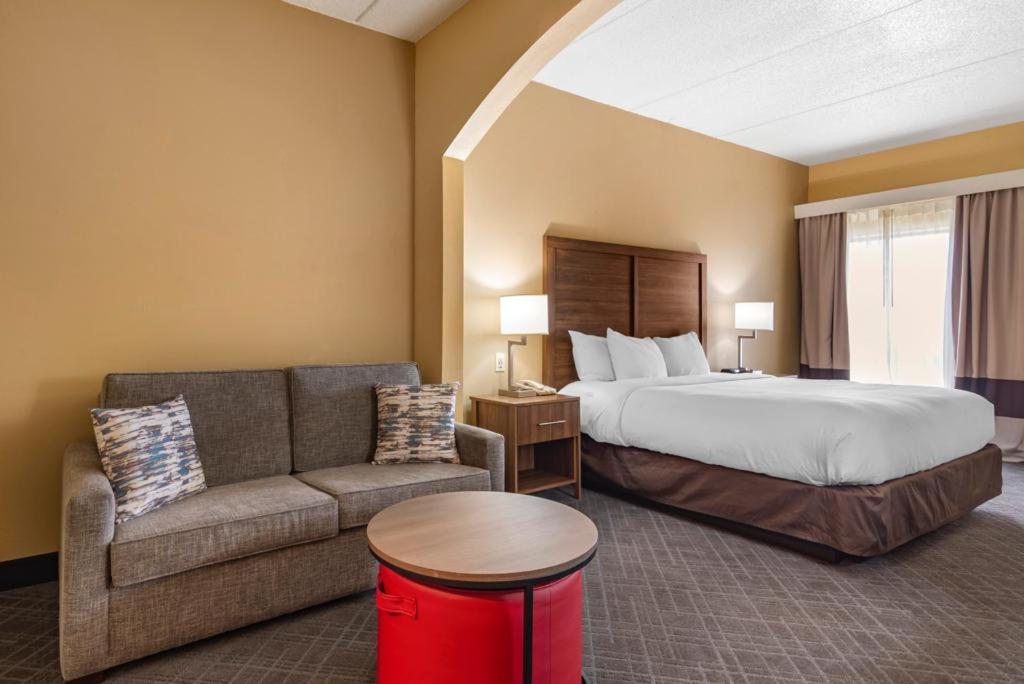 um quarto de hotel com uma cama e um sofá em Comfort Inn & Suites at Stone Mountain em Stone Mountain