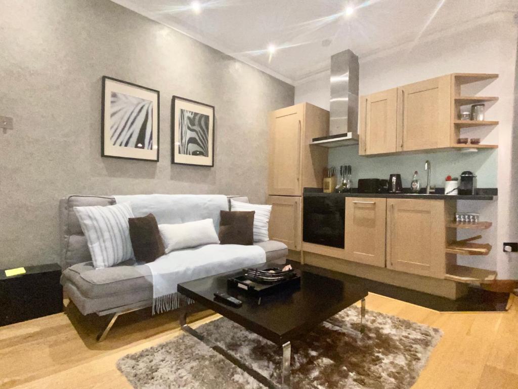 un soggiorno con divano e tavolo di Luxury apartment in Central London, Mida Vale a Londra