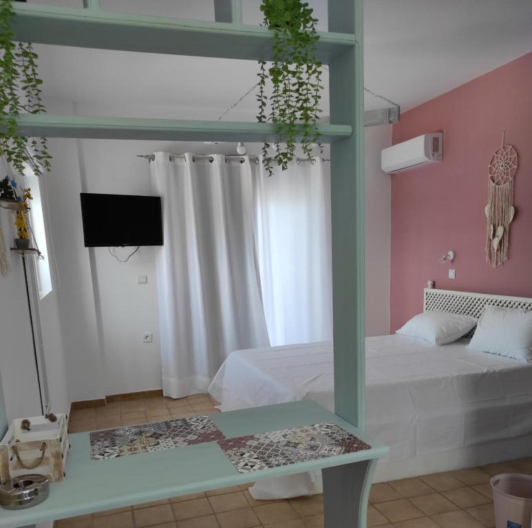 een slaapkamer met een bed en een tv in een kamer bij Arocaria - Faliraki peaceful apartments in Faliraki