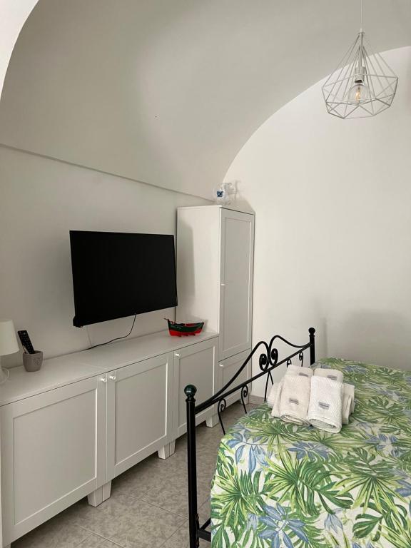 - une chambre avec un lit et une télévision à écran plat dans l'établissement Nonno Tommy, à Polignano a Mare