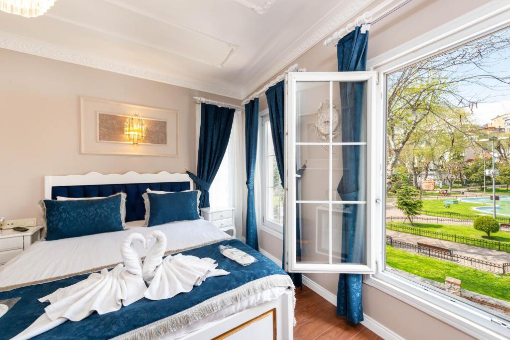 ein Schlafzimmer mit einem Bett und einem großen Fenster in der Unterkunft Begonville Corner in Istanbul