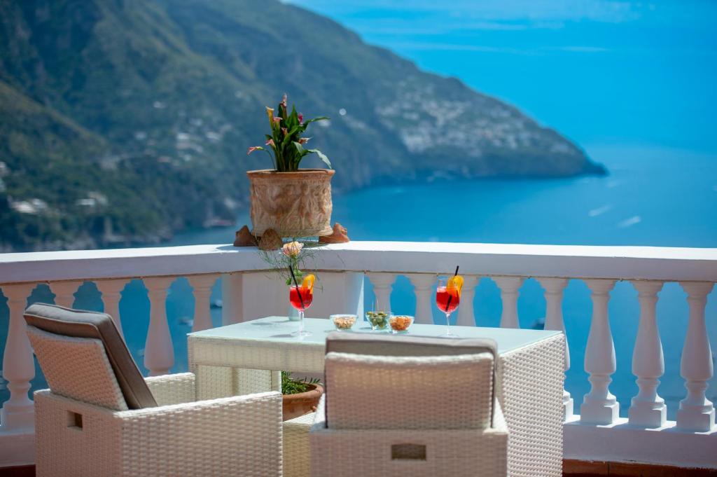 a table and chairs on a balcony with a view of the ocean at Villa Briganti Seaview Terrace in Positano