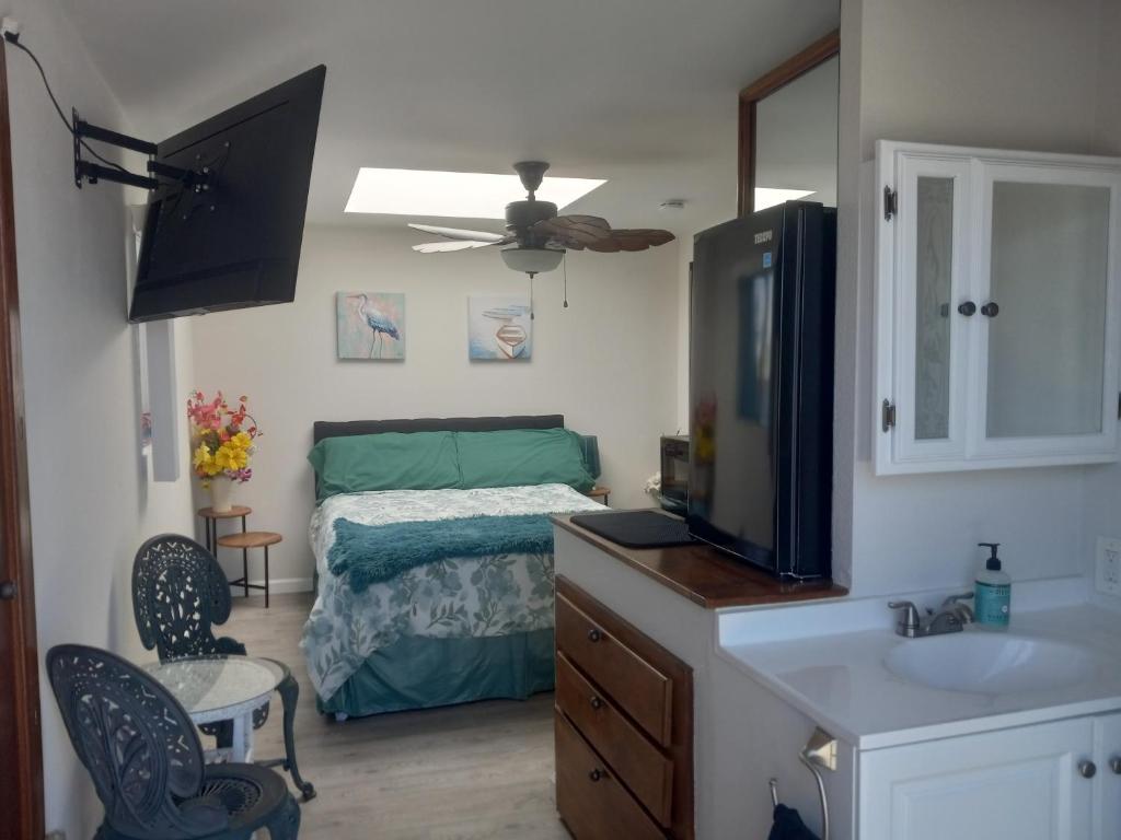 a bedroom with a bed and a flat screen tv at SHARED TOWNHOUSE in MISSION BEACH in San Diego