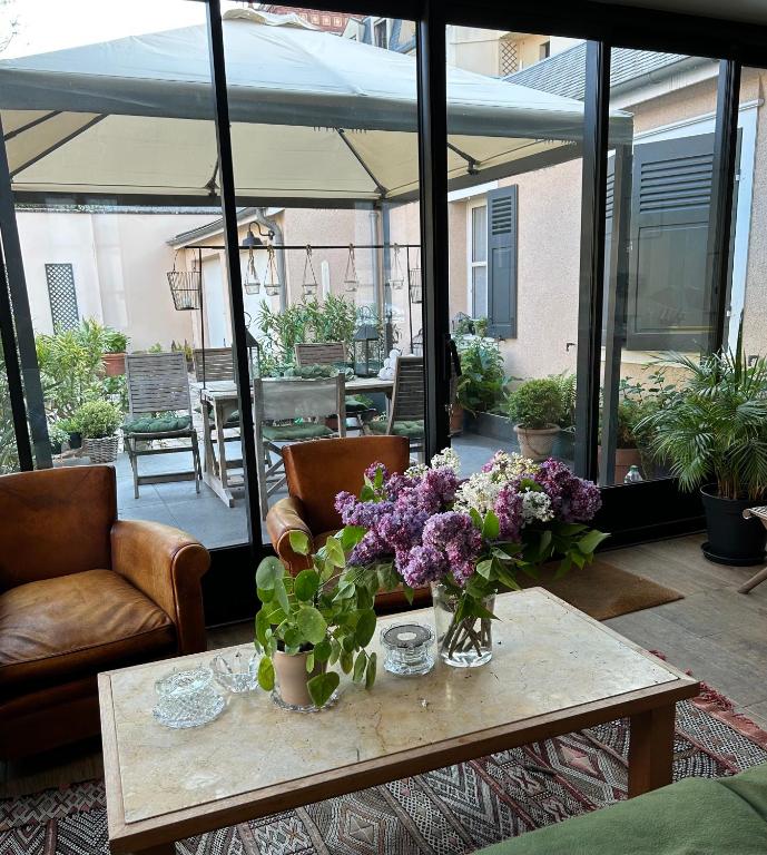 a living room with a table with flowers on it at Le Jardin Cathedrale in Chartres