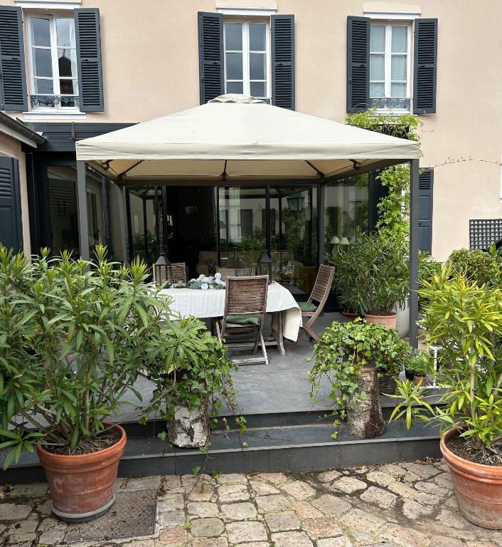 a table and chairs under an umbrella on a patio at Le Jardin Cathedrale in Chartres