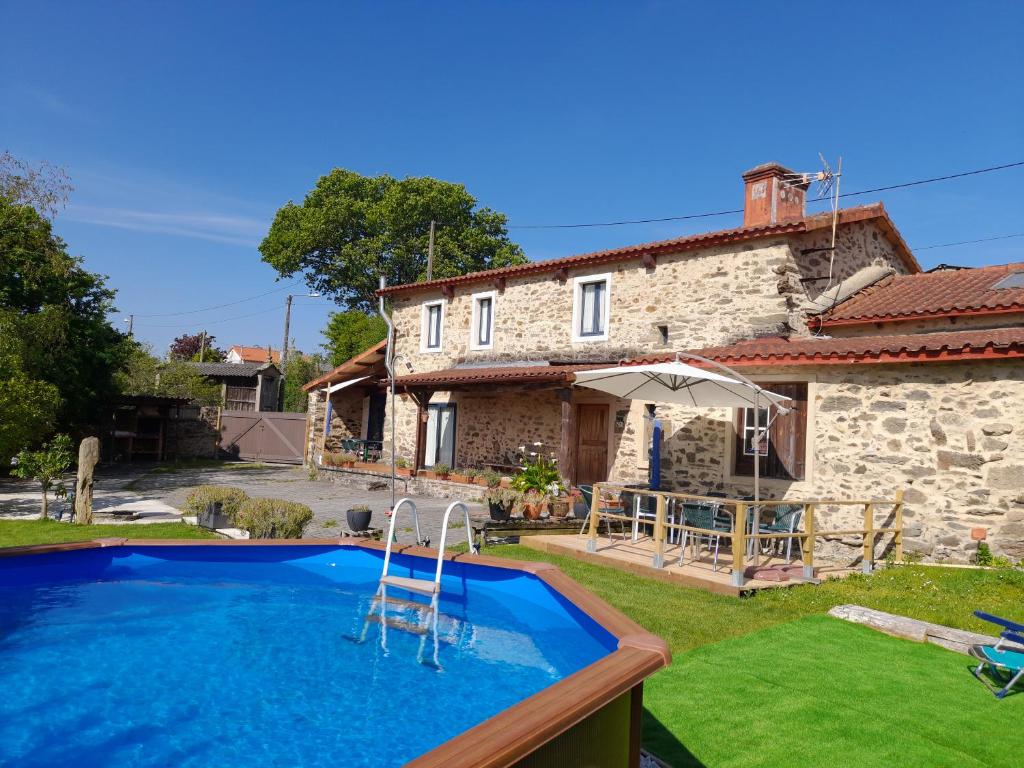 a country house with a swimming pool in front of a house at Casa Fonte do Barro SPA opcional, de pago in Santiago de Compostela