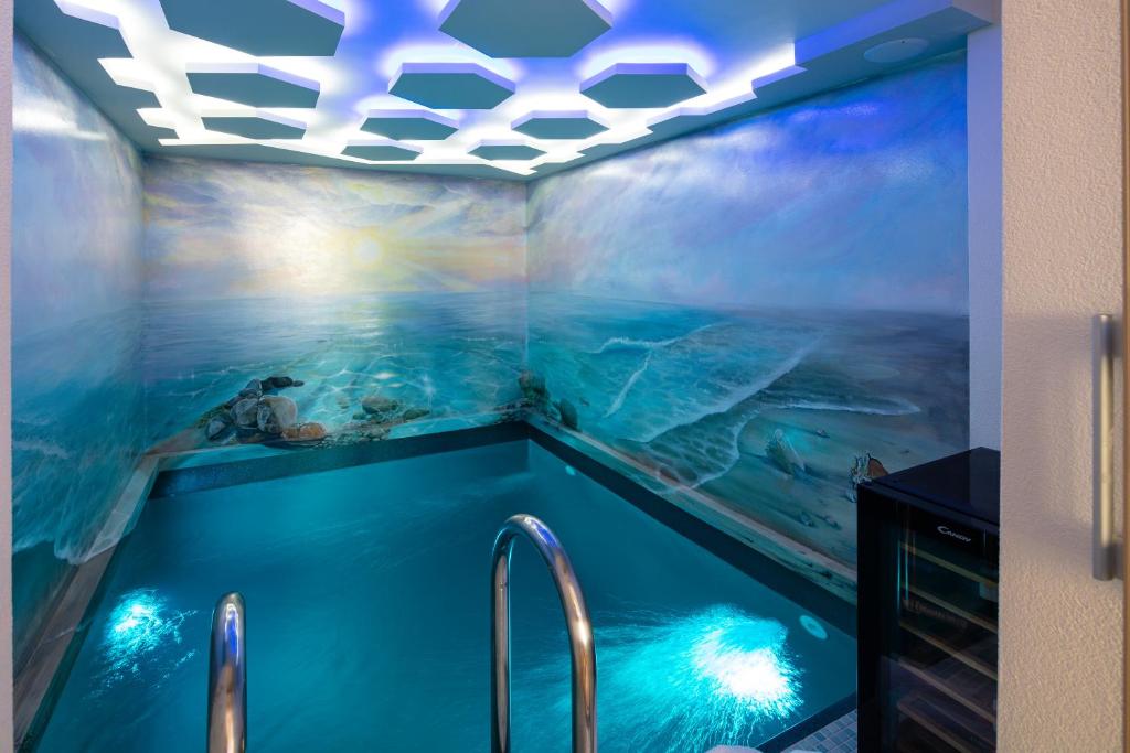 a swimming pool in a room with a painting of the ocean at De President Suite, DeMaNi President Suites in Sitia