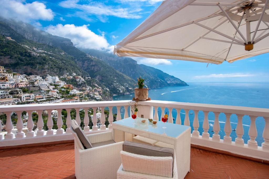 a table and chairs on a balcony with a view of the ocean at Villa Briganti Seaview Terrace in Positano
