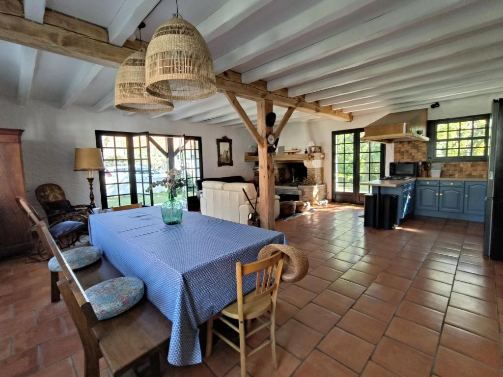 eine Küche und ein Esszimmer mit einem blauen Tisch und Stühlen in der Unterkunft Villa Yéyéyette spacieuse 6 à 8 personnes in Andernos-les-Bains