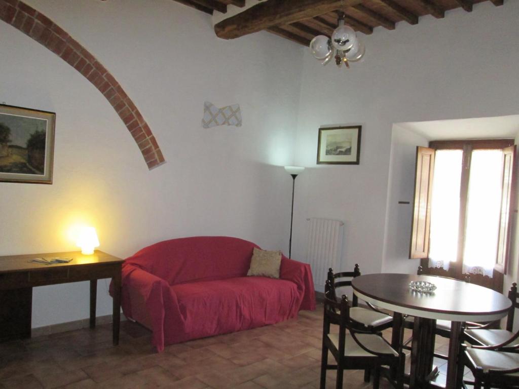 a living room with a red couch and a table at Casa Vacanze Sasso Pisano in Sasso Pisano