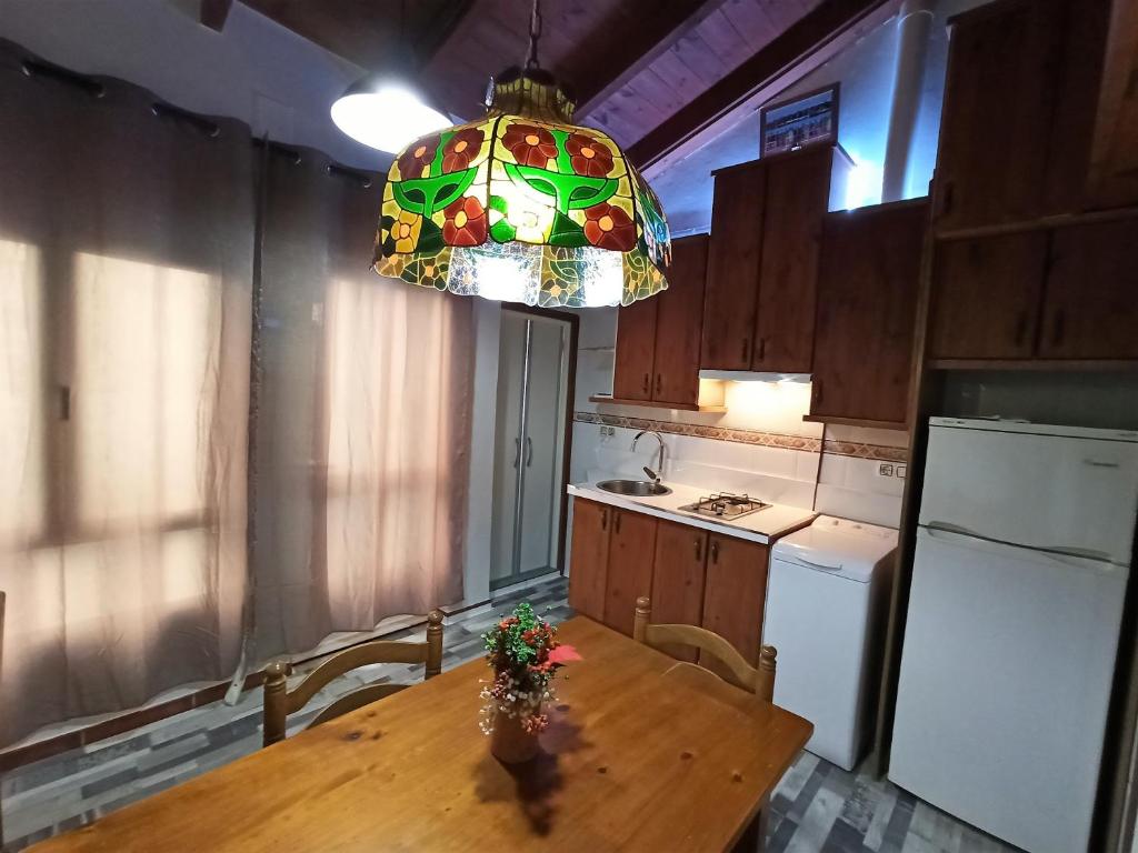 cocina con mesa de madera y lámpara de araña en Studio La Casita, en Gijón