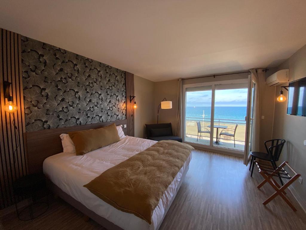 a bedroom with a bed and a view of the ocean at Hôtel Mar I Cel &amp; Spa in Canet-en-Roussillon