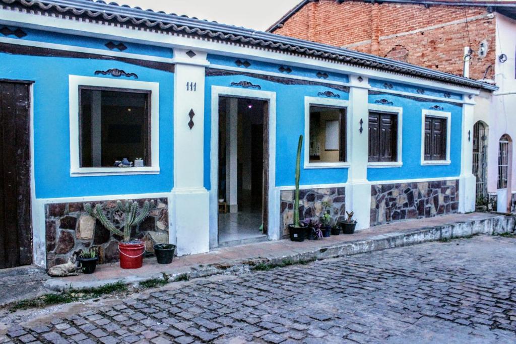 a blue and white building on a cobblestone street at Buena Vibe Hostel in Lençóis