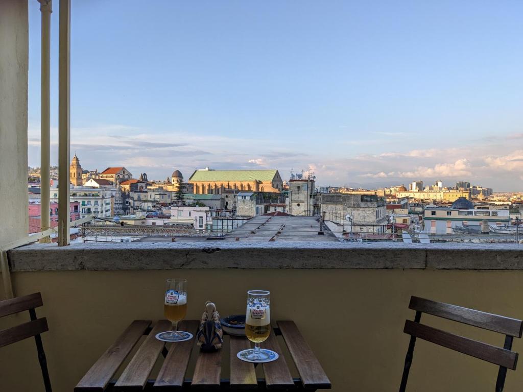 ein Tisch mit zwei Gläsern Wein auf einem Balkon in der Unterkunft Napoli City Panorama in Neapel