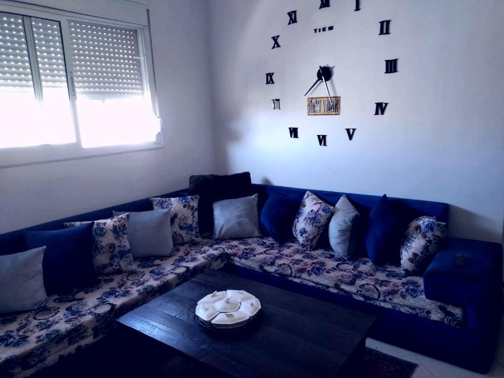 a blue couch in a living room with a table at Repose toi c comme chez soi in Oujda