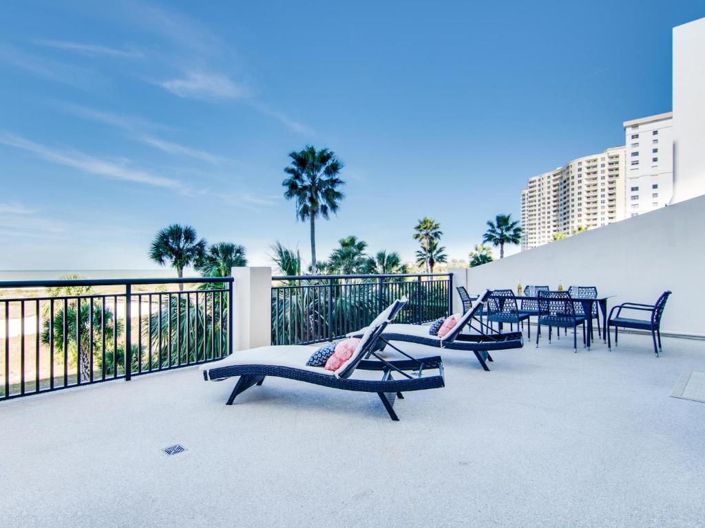 a patio with chairs and tables on a balcony at Harbour Light Towers 307 3rd Floor Beachfront 2 Bedroom Harbour Light Towers in Clearwater Beach