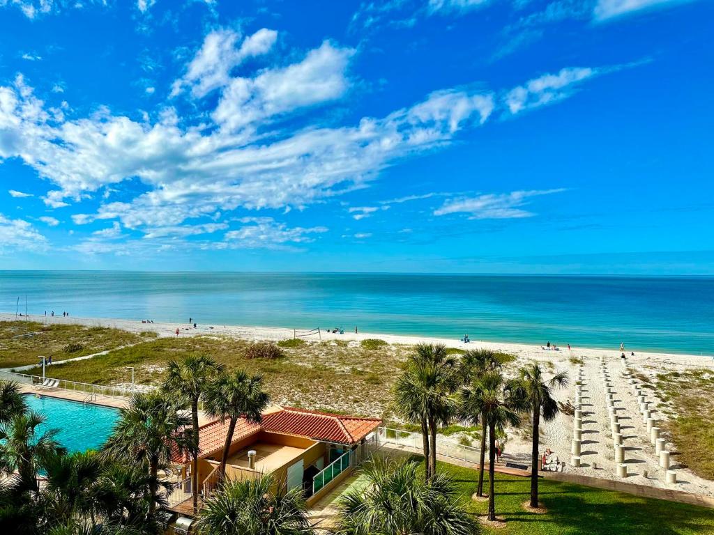a view of a beach with palm trees and a building at Regatta Beach Club 403N 90 day min in Clearwater Beach