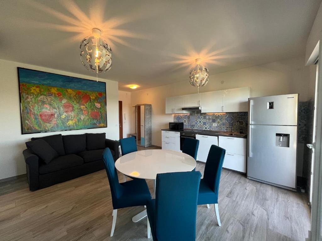 eine Küche und ein Wohnzimmer mit Tisch und Stühlen in der Unterkunft Scaramuzza 7 in Grado