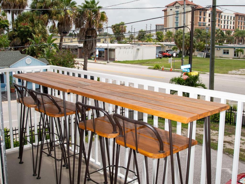 une table et des chaises en bois sur un balcon dans l'établissement Villas of Clearwater Beach 4B Steps from the Beach, à Clearwater Beach
