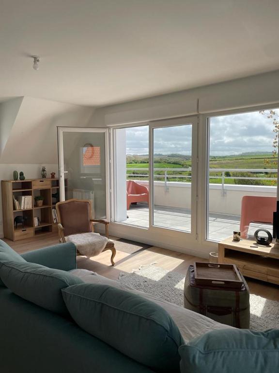 un salon avec un canapé et une grande fenêtre dans l'établissement Le Wim’bowé, à Wimille