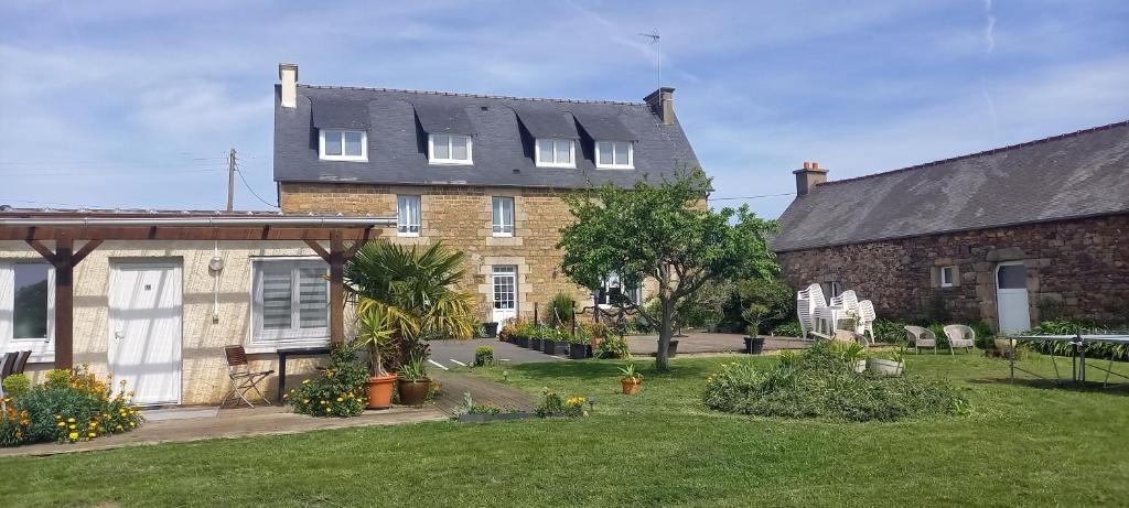 une grande maison en briques avec une cour devant elle dans l'établissement Le Relais De Launay, à Ploubazlanec