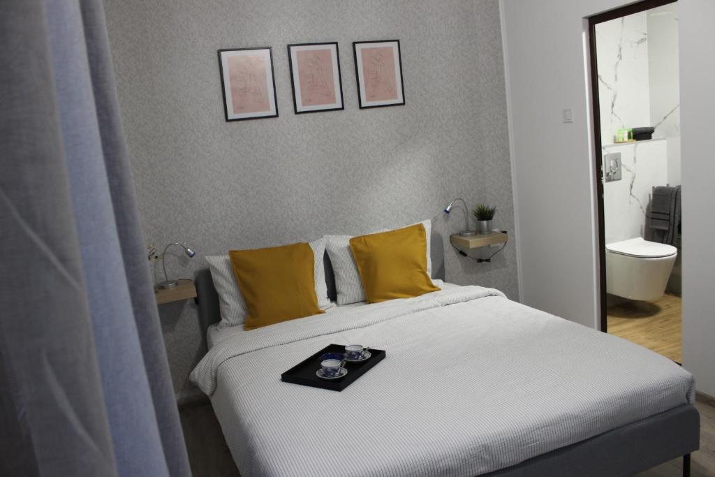 łóżko z żółtymi poduszkami i tacą w obiekcie Orange House in the Old Town Plovdiv w Płowdiwie