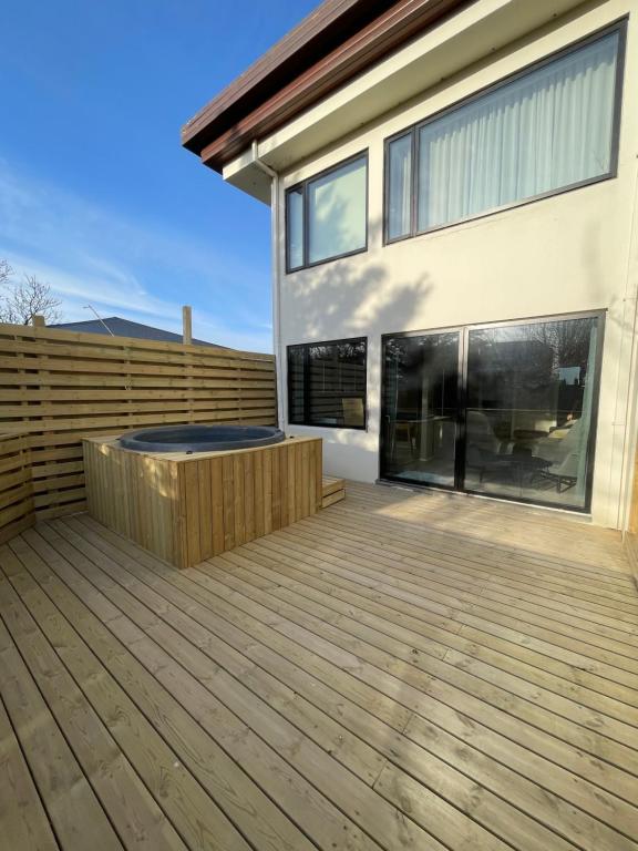 een terras met een hot tub in een huis bij Keflavik Apartments 101 in Keflavík