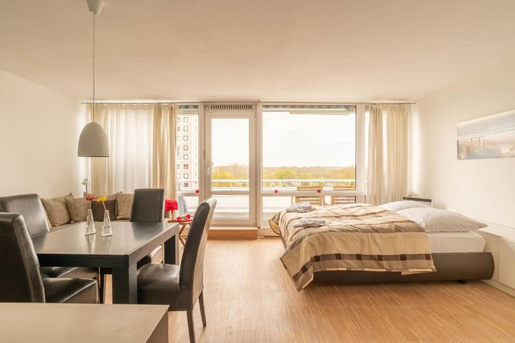 a bedroom with a bed and a table and a dining room at Sonnenanbeter in Strande