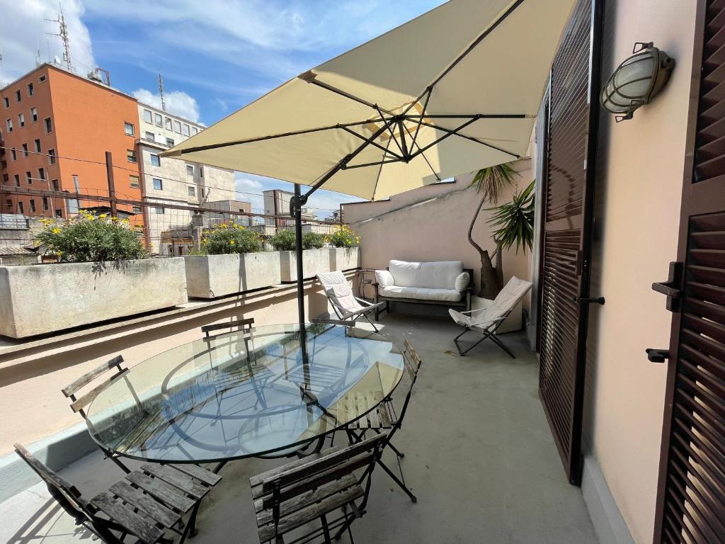 a patio with a table and chairs and an umbrella at Loft Esquilino Terrazza a Stazione Termini in Rome