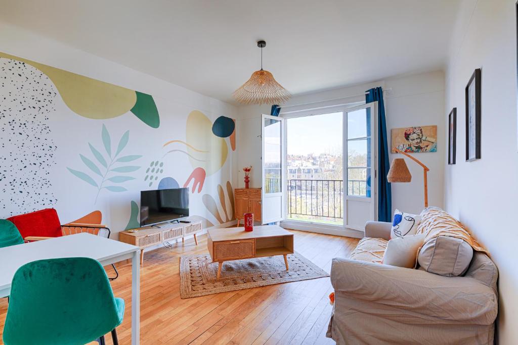 a living room with a couch and a tv at Le "Cassiopée" appartement neuf sur le port de Caen in Caen