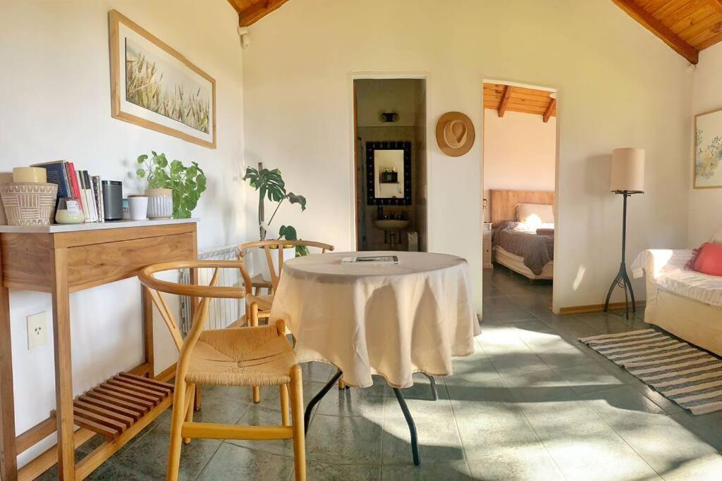 uma sala de estar com uma mesa com cadeiras e uma cama em Casa La Quinta - Tiny House em San Carlos de Bariloche