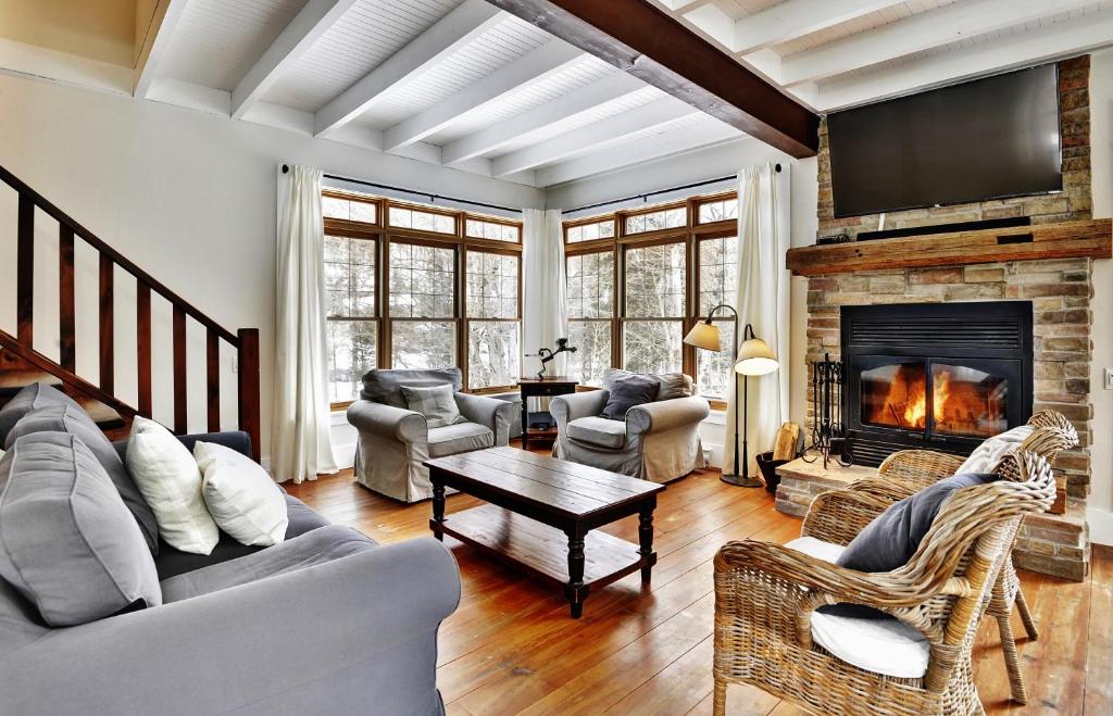 a living room filled with furniture and a fireplace at Chalet 9023 Chemin des Alpages by Les Chalets Alpins in Stoneham