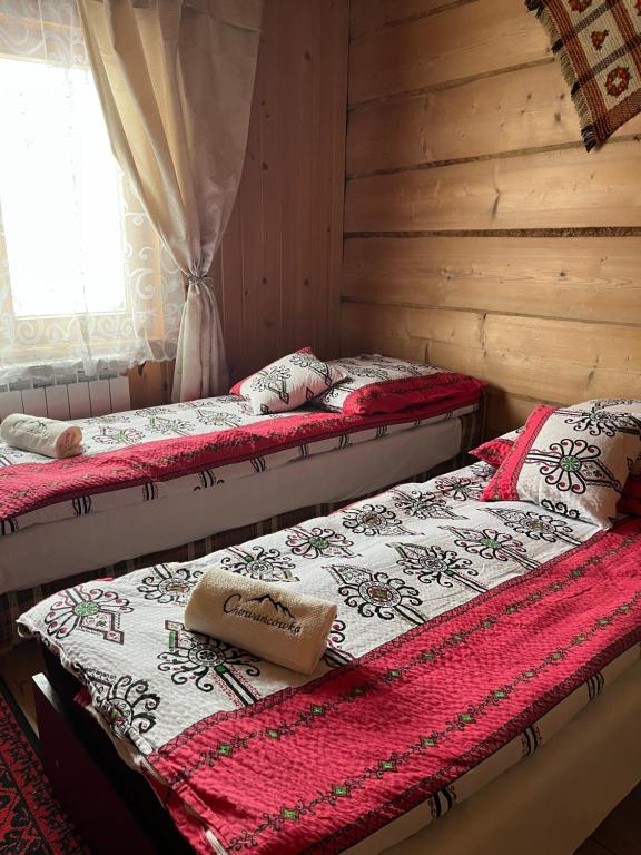 two twin beds in a room with a window at Chowancówka in Biały Dunajec