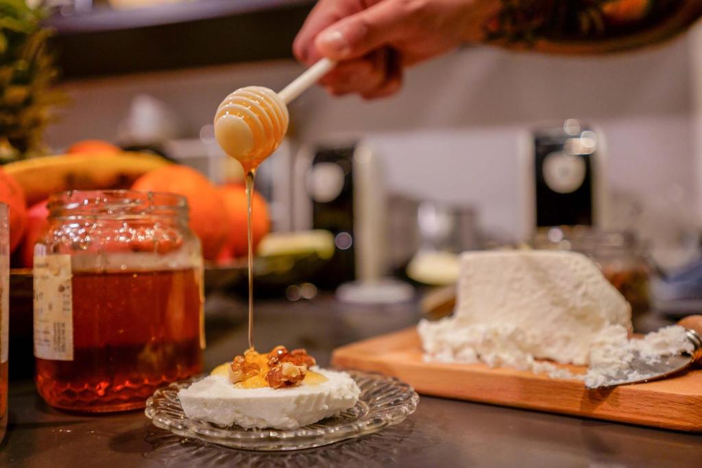 a person drizzling honey onto a piece of food at Il Cagliarese B&B in Cagliari