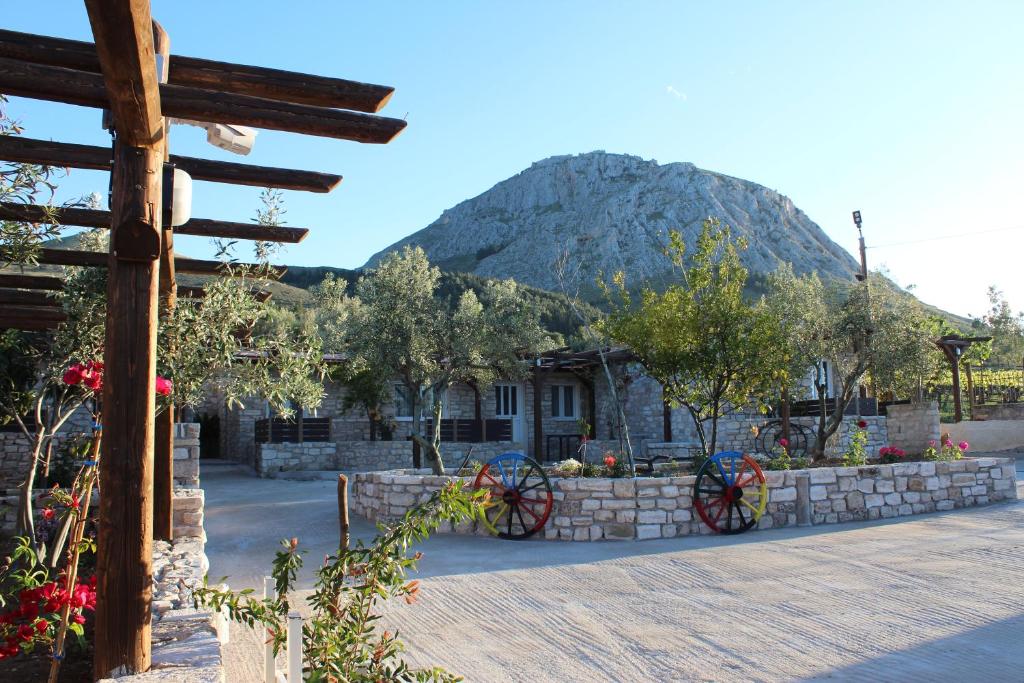 uma casa com uma grande montanha ao fundo em Acrocorinth Apartments em Kórinthos
