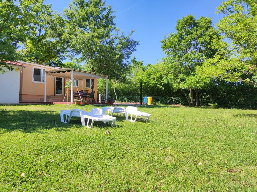 a group of tables and chairs in a yard at Tiny house Dora in Marčana