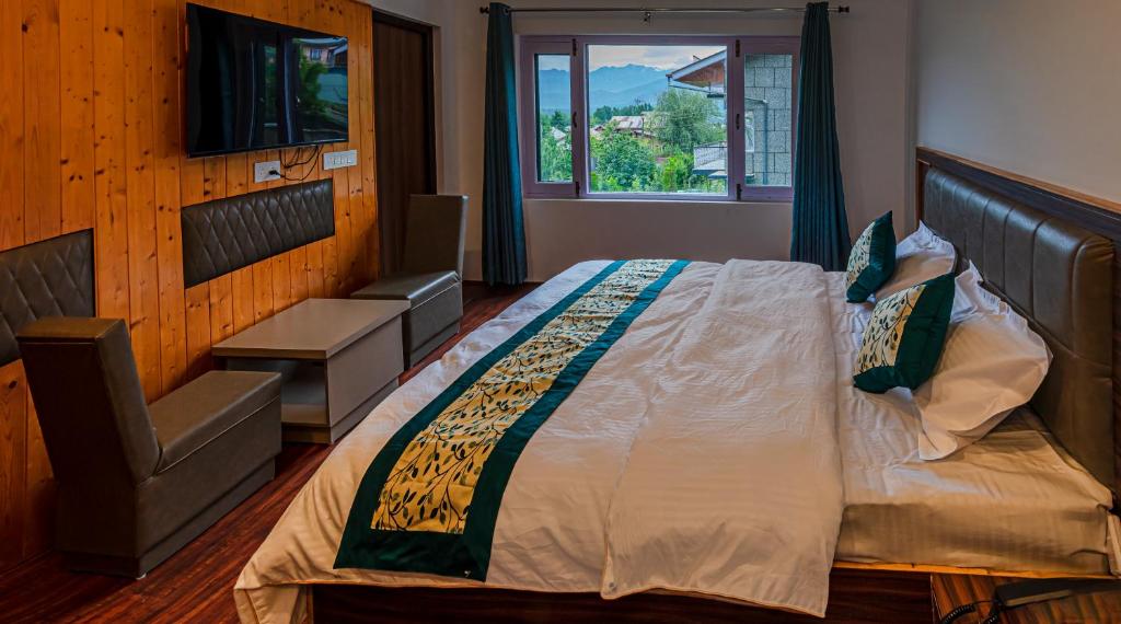 um quarto com uma cama grande e uma cadeira em Hassanz Enclave em Srinagar