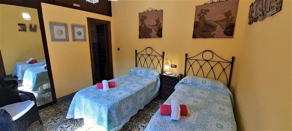 sypialnia z 2 łóżkami pojedynczymi i lustrem w obiekcie Villa Bella Sirena w mieście Nerja