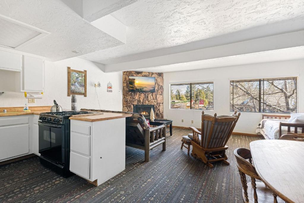a kitchen and living room with a table and chairs at 02- American Black Bear At Village Suites Inn in Big Bear Lake