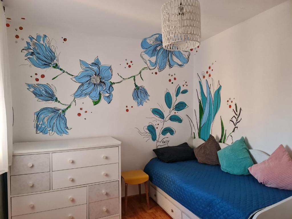 Rotem Home في حيفا: غرفة نوم مع الزهور الزرقاء على الحائط