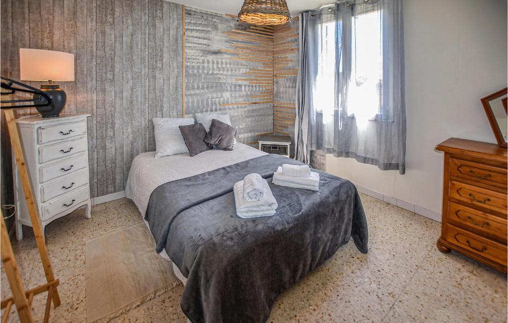 a bedroom with a bed and a dresser and a window at Amazing Home In Lapalud With Outdoor Swimming Pool, Wifi And Private Swimming Pool in Lapalud