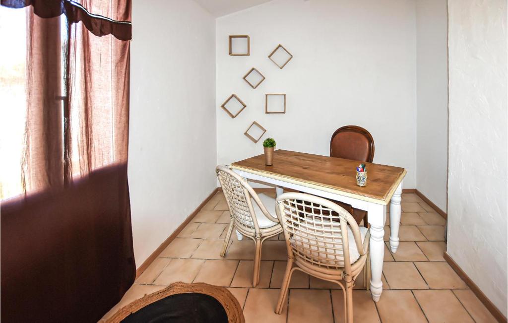 a table and chairs in a room with a window at Amazing Home In Lapalud With Outdoor Swimming Pool, Wifi And Private Swimming Pool in Lapalud