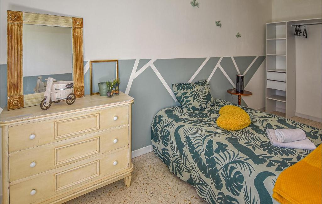 a bedroom with a bed with a dresser and a mirror at Amazing Home In Lapalud With Outdoor Swimming Pool, Wifi And Private Swimming Pool in Lapalud