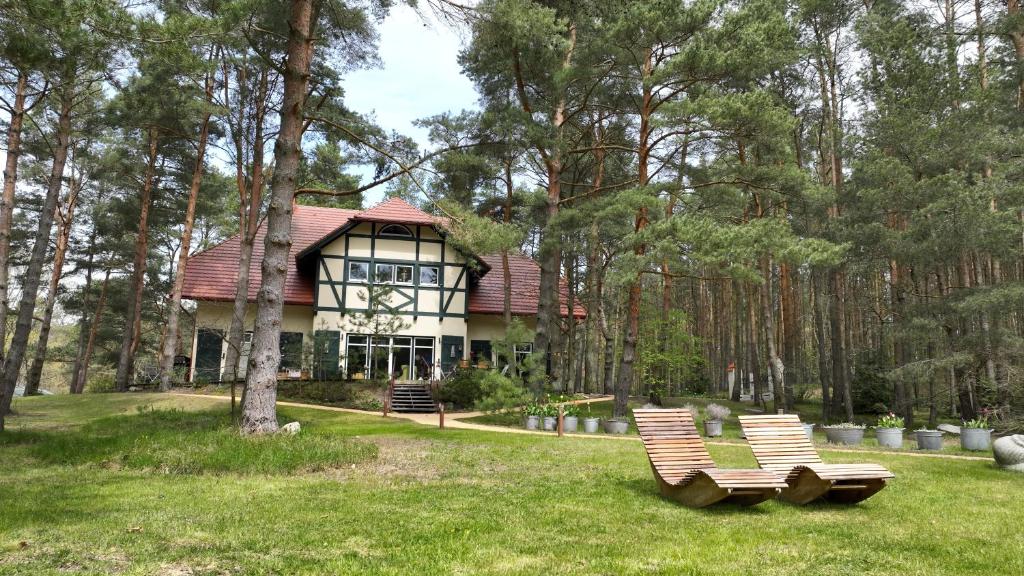 a house with a bench in front of it at Pension Kalmus in Smołdziński Las