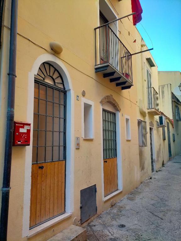 a building with wooden doors on a street at A casa SCALILLA in Palermo