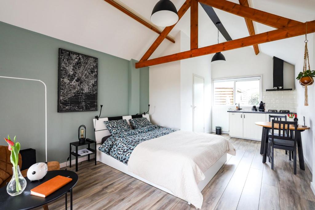 um quarto com uma cama, uma mesa e uma cozinha em Huisje Sasa em Hierden